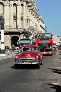 Vintage car from the 50s in the centre of Havana, open tourist bus in the back, Centro Habana,