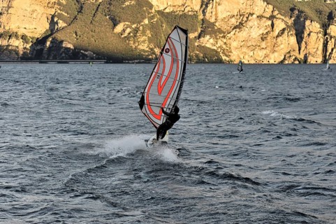 Windsurfers surfing in strong winds on Lake Garda near Malcesine, Veneto, Italy, Europe