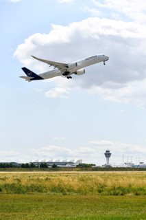 Lufthansa Airlines Airbus A350-900 taking off on Runway North with control tower, Munich Airport,