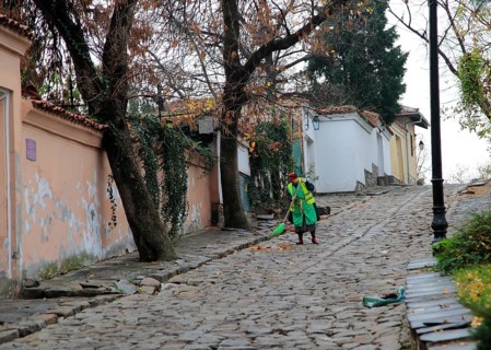 Woman sweeping cobbled street in old town of Plovdiv, Bulgaria, eastern Europe, Europe