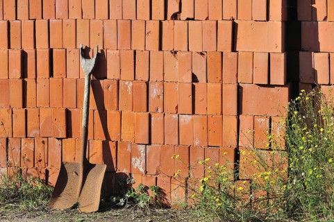 Shovel and pile of stacked red bricks at brickworks, Boom, Belgium, Europe