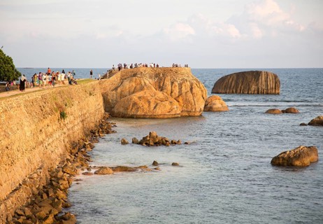 Tourists walk on fort ramparts in historic town of Galle, Sri Lanka, Asia