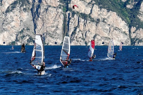 Windsurfers surfing in strong winds on Lake Garda near Malcesine, Veneto, Italy, Europe