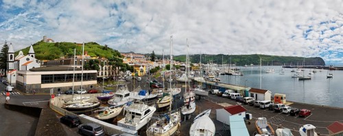 Wide angle shot of the harbour of Horta with boats, buildings and cars on the coastal road, Horta,