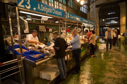 People shopping at fishmonger stalls inside historic covered market building, Jerez de la Frontera,