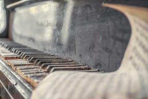An old, dust-covered piano with worn black and white keys, urologist's villa Dr Anna L., Lost