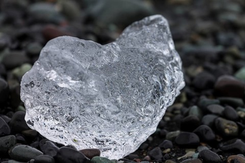 A piece of glacial ice, melting on the black sand beach near Joekulsarlon glacial lake on the