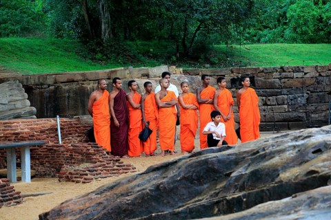 Orange robed monks, Gal Viharaya, UNESCO World Heritage Site, the ancient city of Polonnaruwa, Sri
