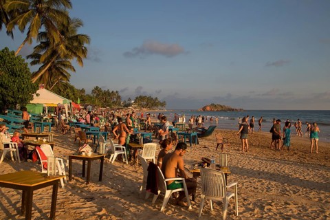 People sitting at tables of beach bar, Mirissa, Sri Lanka, Asia
