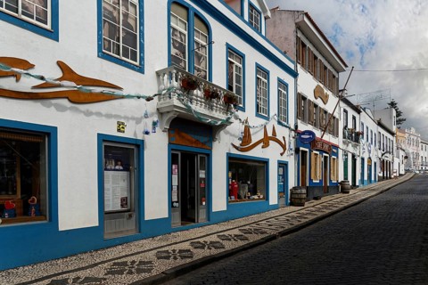 Street view with traditional with the famous Cafe Sport, blue decorated buildings and cobbled path,