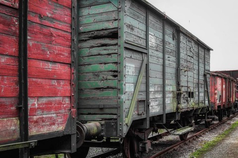 A weathered red and green goods wagon stands on tracks in the railway museum, Dahlhausen railway
