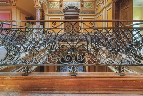 Detailed wrought-iron railing on an elegant staircase with wooden steps, Villa Woodstock, Lost