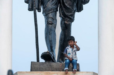 Child at the foot of a Mahatma Gandhi monument, statue, former French colony of Pondicherry or
