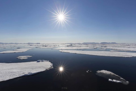 Midnight sun over the Arctic Ocean with drifting ice floes, north of the Arctic Circle at