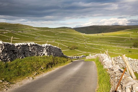 Country lane and dry stonewalls, Malham, Yorkshire Dales national park, England, UK