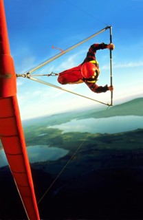 Hang glider pilot with red hangglider and red helmet in a steep curve, also called knife flight,