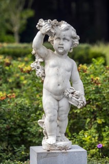 Angel statue in covered in bird droppings in park, garden of Ooidonk Castle, Kasteel van Ooidonk at