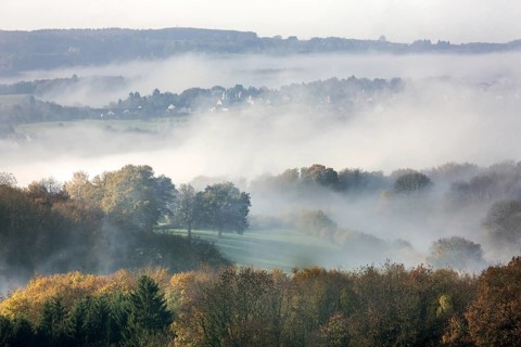 View over fileds and the village Sougne-Remouchamps in the mist, Aywaille, Liege, Belgian Ardennes,