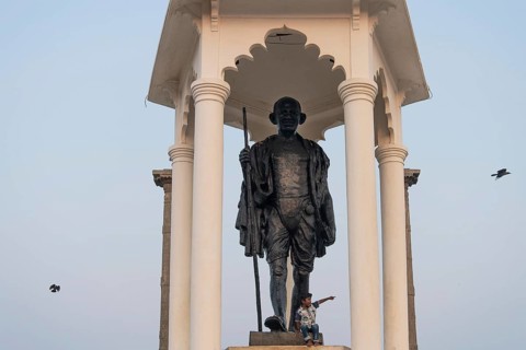 Child at the foot of a Mahatma Gandhi monument, statue, former French colony of Pondicherry or