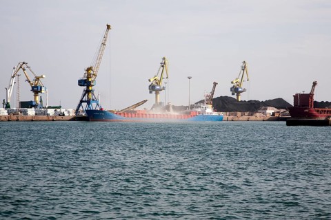 Cranes loading bulk carrier ship with rock ore at the port of Beni Ansar, Morocco, north Africa,