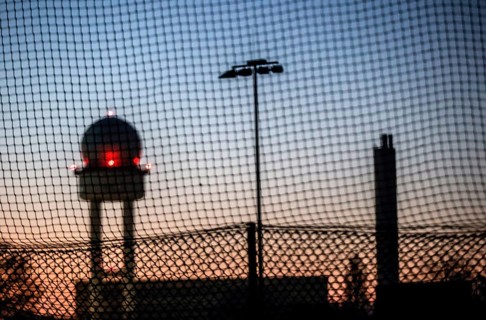 Evening mood at Tempelhofer Feld, view through a fence to the radar tower at the former Tempelhof