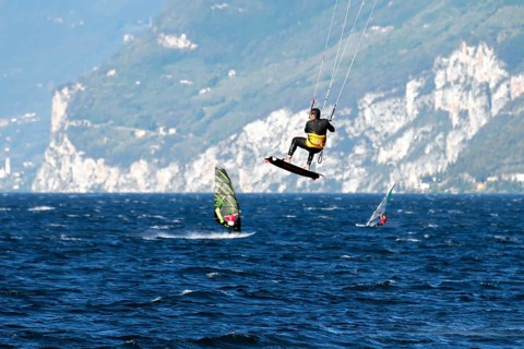 Windsurfers surfing in strong winds on Lake Garda near Malcesine, Veneto, Italy, Europe