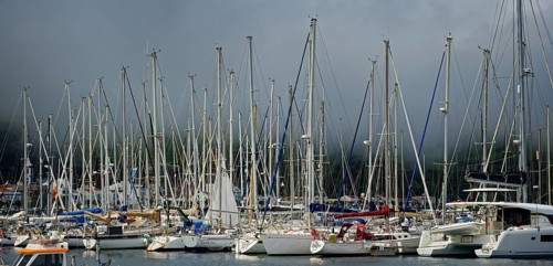Sailboats in the sunny harbour of Horta with dark clouds above, Horta, Faial Island, Azores,