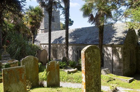 Historic gravestones and church amidst sub-tropical plants, St Just in Roseland, Cornwall, England,