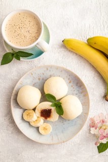 Japanese rice sweet buns mochi filled with jam and cup of coffee on a gray concrete background. top