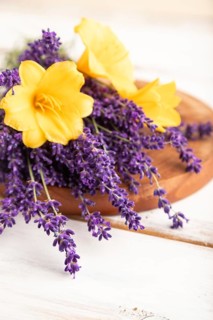 Beautiful day lily and lavender flowers on white wooden background, side view, close up, selective