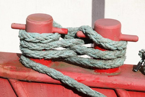 Red ship's bollard wrapped with ship's rope, mooring line, Germany, Europe