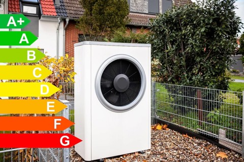 Air heat pump in front of an apartment block, graphic with energy efficiency classes for buildings