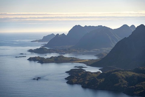 View of the coast in Ulvagsundet fjord and mountains in the evening light, Hurtigruten cruise ship