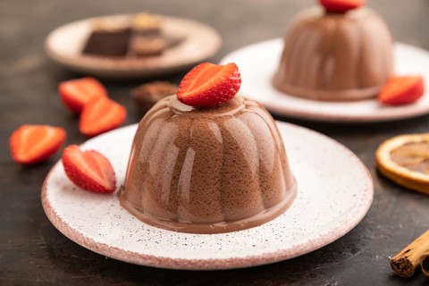 Chocolate jelly with strawberry on black concrete background. side view, close up, selective focus