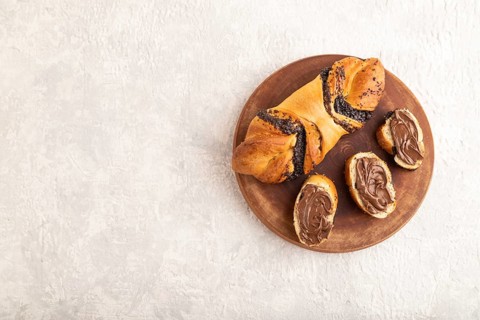 Homemade sweet bun with chocolate cream on a gray concrete background. top view, flat lay, copy