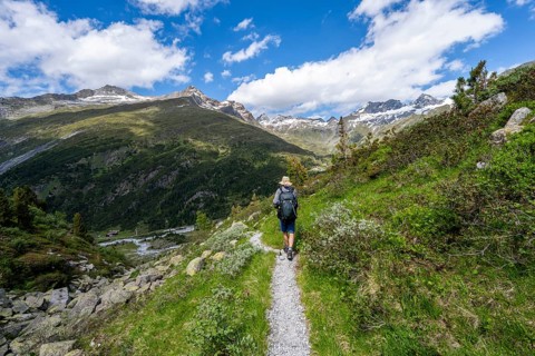 Mountaineers on a hiking trail in front of a picturesque mountain landscape, rocky mountain peaks