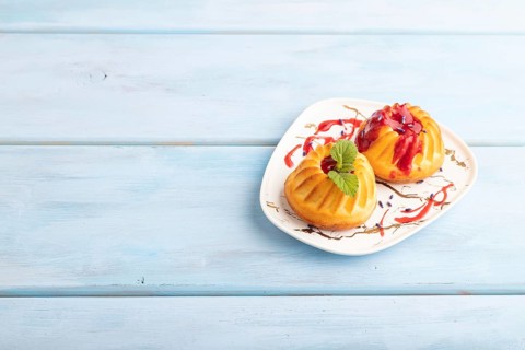 Semolina cheesecake with strawberry jam, lavender, on blue wooden background. side view, copy space