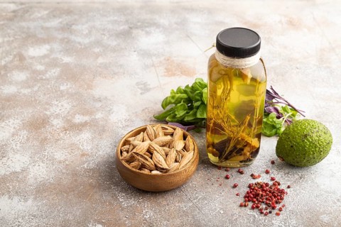 Sunflower oil in a glass jar with various herbs and spices, sesame, rosemary, avocado, basil,
