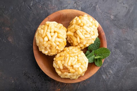 Traditional Tatar candy chak-chak made of dough and honey in wooden plate on a black concrete