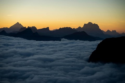 Sunrise over a sea of fog with the peaks of the Sella massif in the background, Corvara, Dolomites,