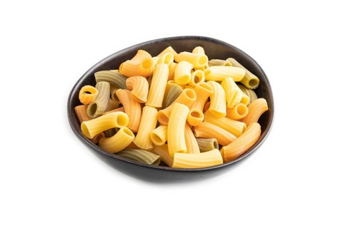 Rigatoni colored raw pasta in bowl isolated on white background. Side view