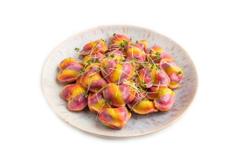 Rainbow colored dumplings with pepper, herbs, microgreen isolated on white background. Side view