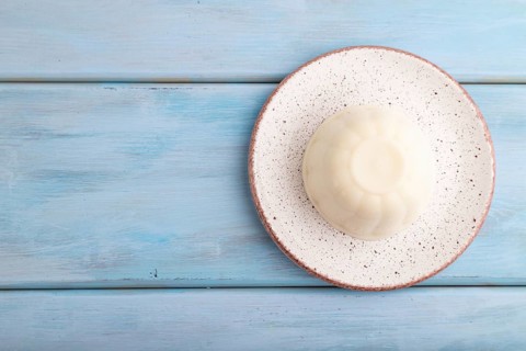 White milk jelly on blue wooden background. top view, flat lay, copy space