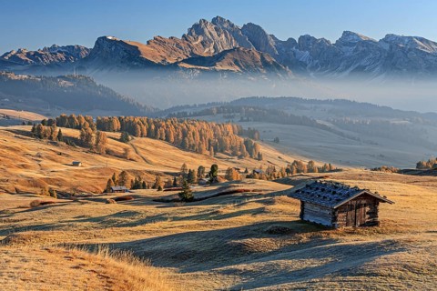 Small hut on alp in front of mountains in the morning light, hoarfrost, autumn, haze, Alpe di