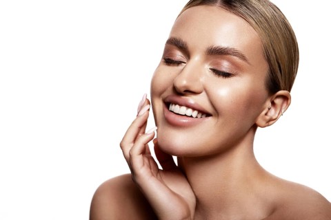 Beauty portrait of model with natural make-up. Fashion shiny highlighter on skin, sexy gloss lips