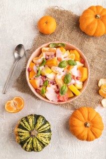 Vegetarian fruit salad of yogurt pumpkin, tangerine, pomegranate, grapefruit, basil microgreen