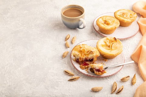 Traditional portuguese cakes pasteis de nata, custard small pies with almonds with cup of coffee on