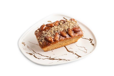 Caramel and almond cake isolated on white background. side view, close up