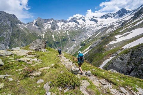 Mountaineer on hiking trail in picturesque mountain landscape, in the background mountain peak