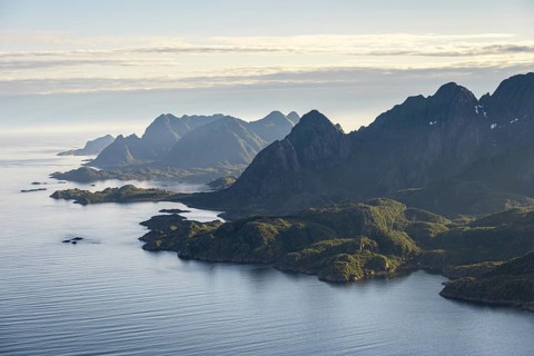 View of the coast in Ulvagsundet fjord and mountains in the evening light, Hurtigruten cruise ship